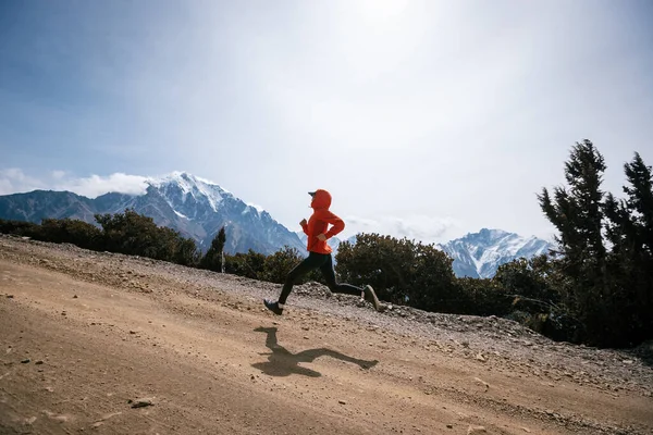 女子赛跑选手在高山上跑过国境 — 图库照片