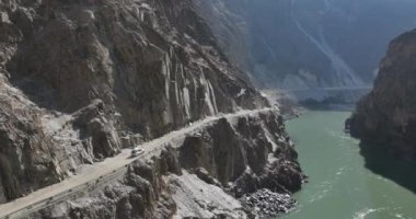 Dağlardaki yolda giden arabanın hava görüntüsü.