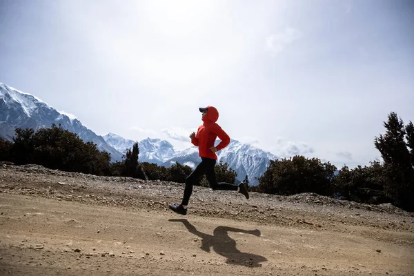 女子赛跑选手在高山跑道上跑过国境 — 图库照片