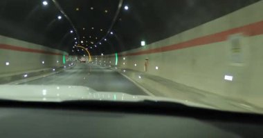 Yeraltı tünelinde ışıklarla giden araba.
