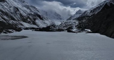 Karlı dağlarda ve donmuş nehirde güzel bir manzara.