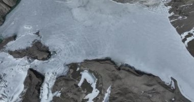 Karlı dağlarda ve donmuş nehirde güzel bir manzara.