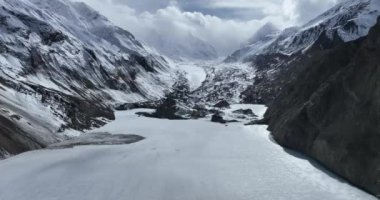 Karlı dağlarda ve donmuş nehirde güzel bir manzara.