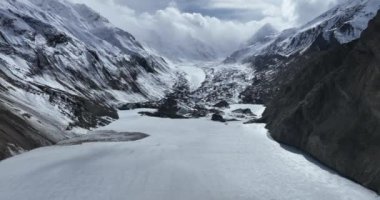 Karlı dağlarda ve donmuş nehirde güzel bir manzara.