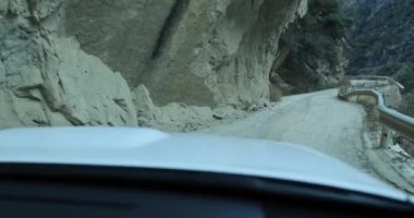 Araba dağlarda yolda gidiyor.