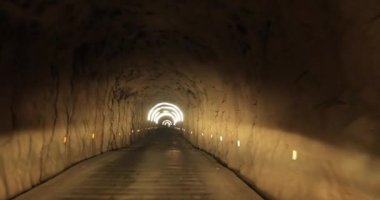 Yeraltı tünelinde ışıklarla giden araba.