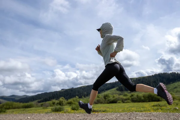 stock image Woman trail runner cross country running at high altitude grassland