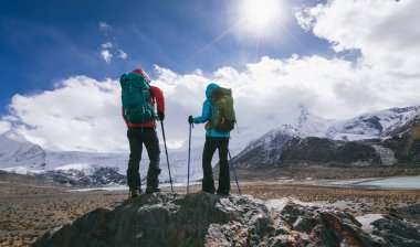 Kadın yürüyüşçüler buzulların manzarasının keyfini çıkarırlar.