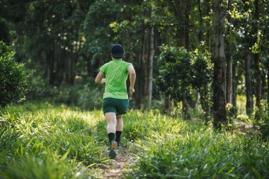Tropikal orman dağlarında koşan bir kadın izci.