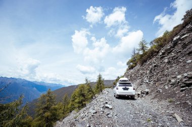 Çin 'in Sichuan eyaletindeki yüksek rakımlı dağlarda off-road araba sürüyorum.