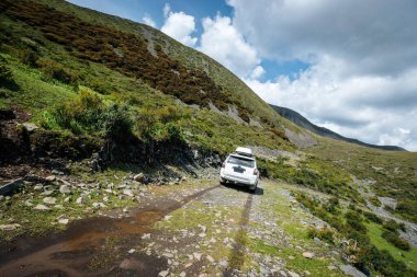 Çin 'in Sichuan eyaletindeki yüksek rakımlı dağlarda off-road araba sürüyorum.