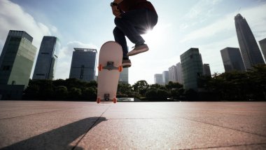 Modern şehirde Asyalı kaykaycı kadın.