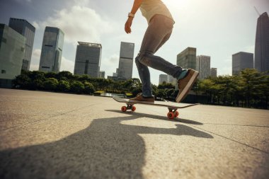 Kaykaycı şehir dışında kaykay yapıyor.