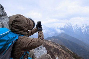 Tibet 'te dağın zirvesinde başarılı bir yürüyüşçü kadın.
