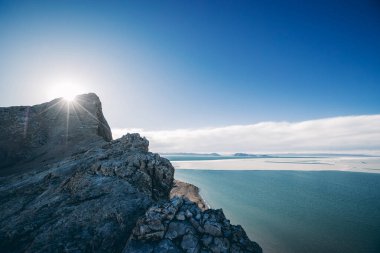 Göl kıyısındaki dağın tepesinde gün batımı