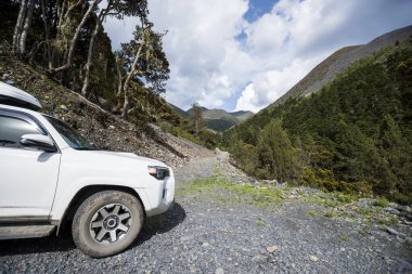 Çin 'in Sichuan eyaletindeki yüksek rakımlı dağlarda off-road araba sürüyorum.