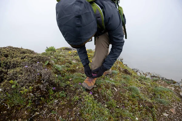 成功的女徒步旅行者在山顶上系鞋带 — 图库照片