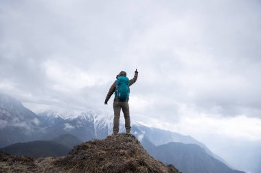 Tibet 'te dağın zirvesinde başarılı bir yürüyüşçü kadın.