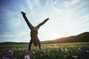 Yüksek rakımlı dağ çayırında bir handstand yapıyor kadın yürüyüşçü