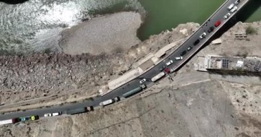 Dağlardaki nehrin havadan görünüşü ve birçok araçla trafik sıkışıklığı.