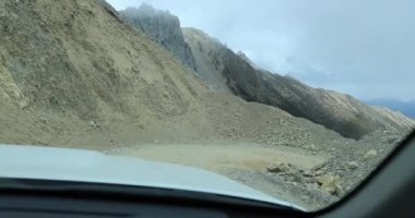 Araba dağlarda yolda gidiyor.