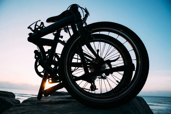 日出海滨路上的折叠式自行车 — 图库照片