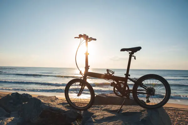 日出海滨路上的折叠式自行车 — 图库照片