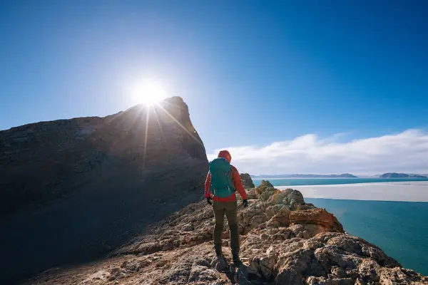 Göl Kenarındaki Dağın Tepesine Tırmanan Bir Kadın Yürüyüşçü — Stok fotoğraf