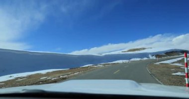 Karlı dağlarda araba sürüyor.