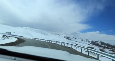 Karlı dağlarda araba sürüyor.