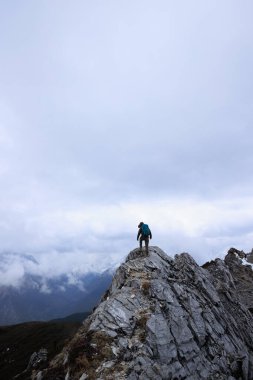 Tibet 'te dağın tepesinde yürüyüş yapan bir kadın.