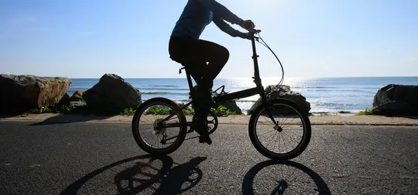 Montar Bicicleta Plegable Salida Del Sol Carretera Costera —  Fotos de Stock