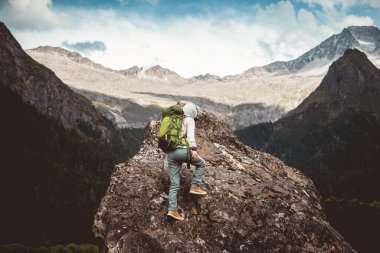 Tibet 'te dağın tepesine tırmanan bir kadın yürüyüşçü
