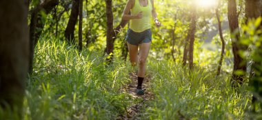 Woman trail runner running at tropical forest mountain peak