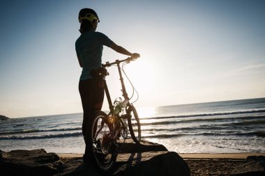 Güneşin doğduğu sahil yolunda bisiklet sürüyorum.