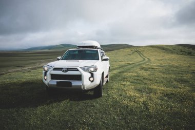 Tibet, Çin - 13 Haziran 2023, Toyota 'yı yüksek rakımlı çayır dağlarında yoldan çıkarmak 