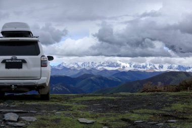 Tibet, Çin - 14 Haziran 2023, Toyota 'yı yüksek rakımlı çayır dağlarında yoldan çıkarmak
