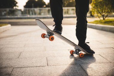 Kaykaycı şehir dışında kaykay yapıyor.