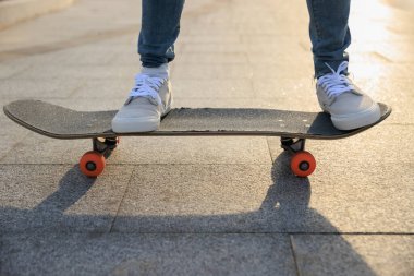 Kaykaycı şehir dışında kaykay yapıyor.