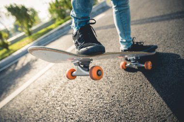 Kaykaycı şehir dışında kaykay yapıyor.