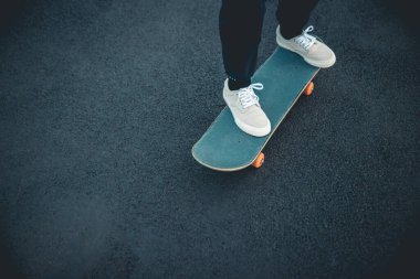 Kaykaycı şehir dışında kaykay yapıyor.