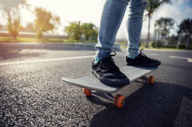 Kaykaycı şehir dışında kaykay yapıyor.