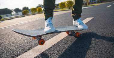 Kaykaycı şehir dışında kaykay yapıyor.