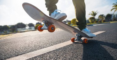 Kaykaycı şehir dışında kaykay yapıyor.