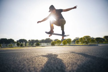 Kaykaycı şehir dışında kaykay yapıyor.