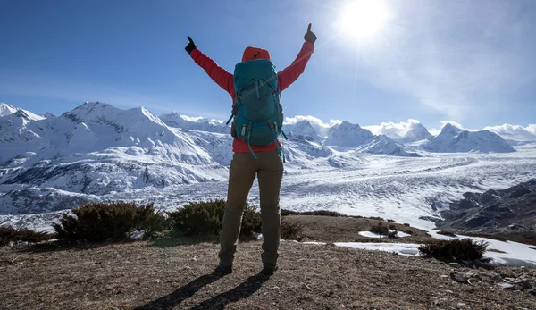 女徒步旅行者欣赏冰川山顶悬崖边缘的景色 — 图库照片