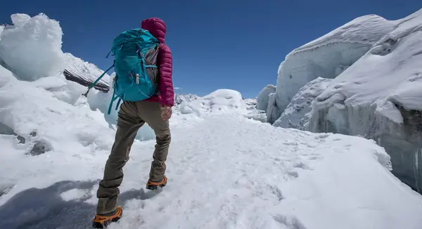 Woman hiker hiking in winter huge glacier mountain,China