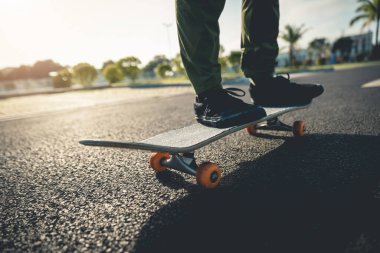 Kaykaycı şehir dışında kaykay yapıyor.