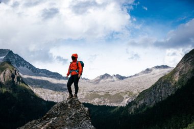 Tibet 'te dağın tepesine tırmanan bir kadın yürüyüşçü