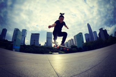 Kaykaycı şehir dışında kaykay yapıyor.